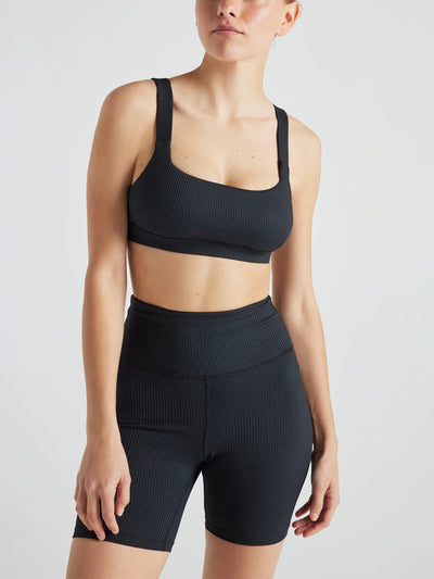 Model wears sustainable square neck black nylon rib sports bra