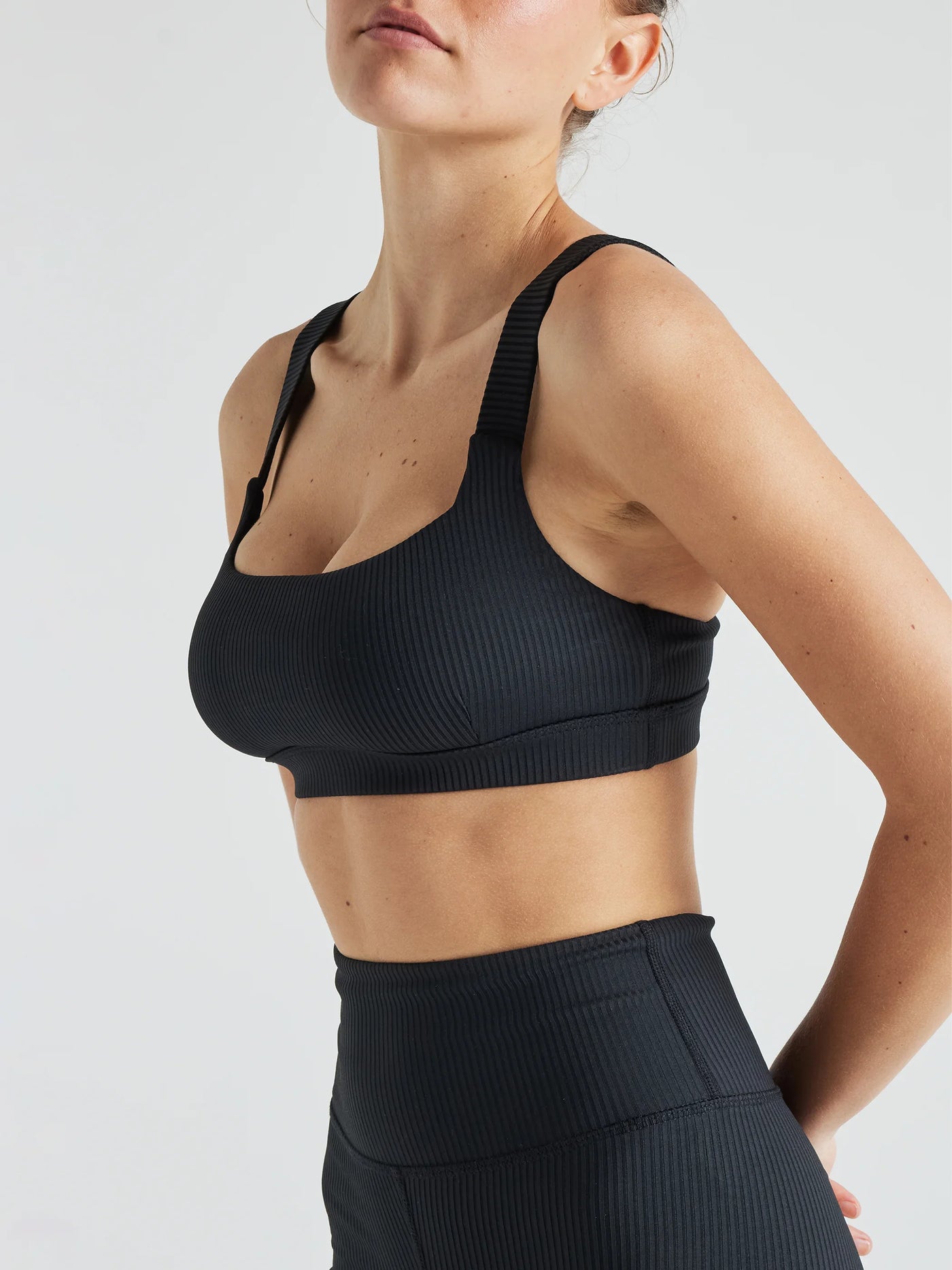 Model wears sustainable square neck black nylon rib sports bra