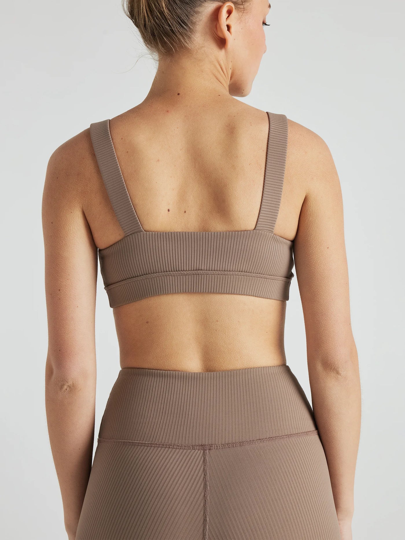 Model wears sustainable square neck light brown nylon rib sports bra