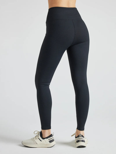 Model wears sustainable black nylon rib leggings