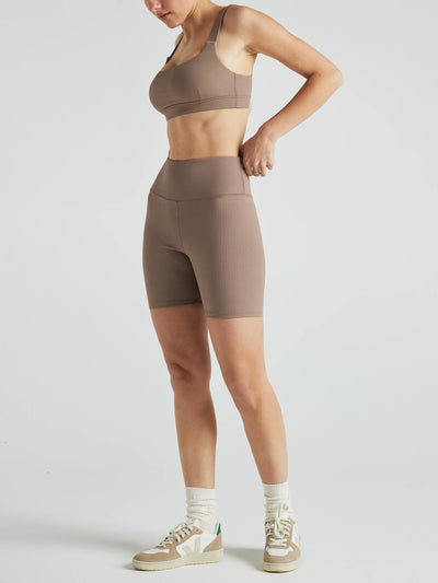 Model wears sustainable light brown nylon rib biker shorts