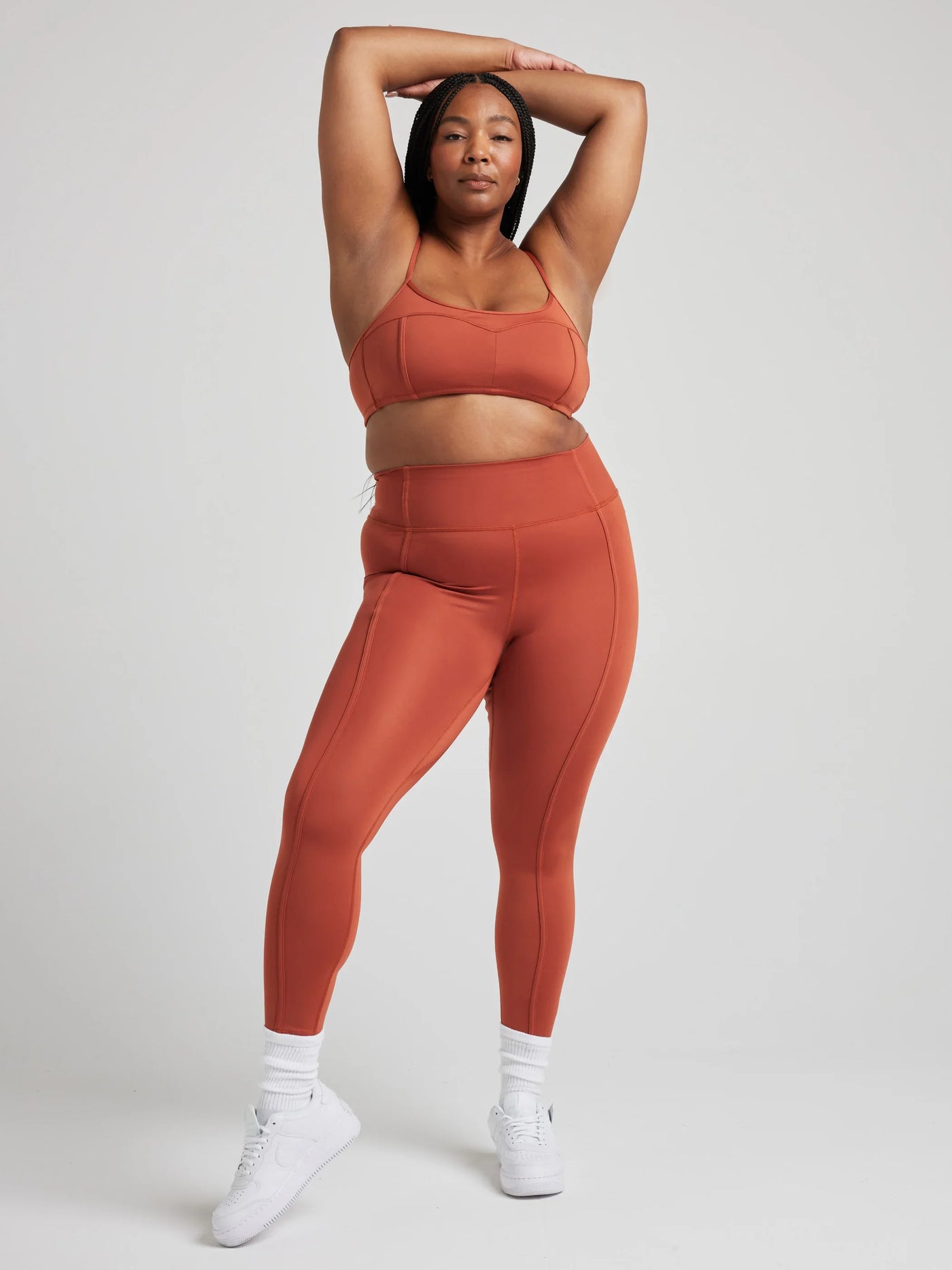 Model poses in burnt orange bralette with corset boning