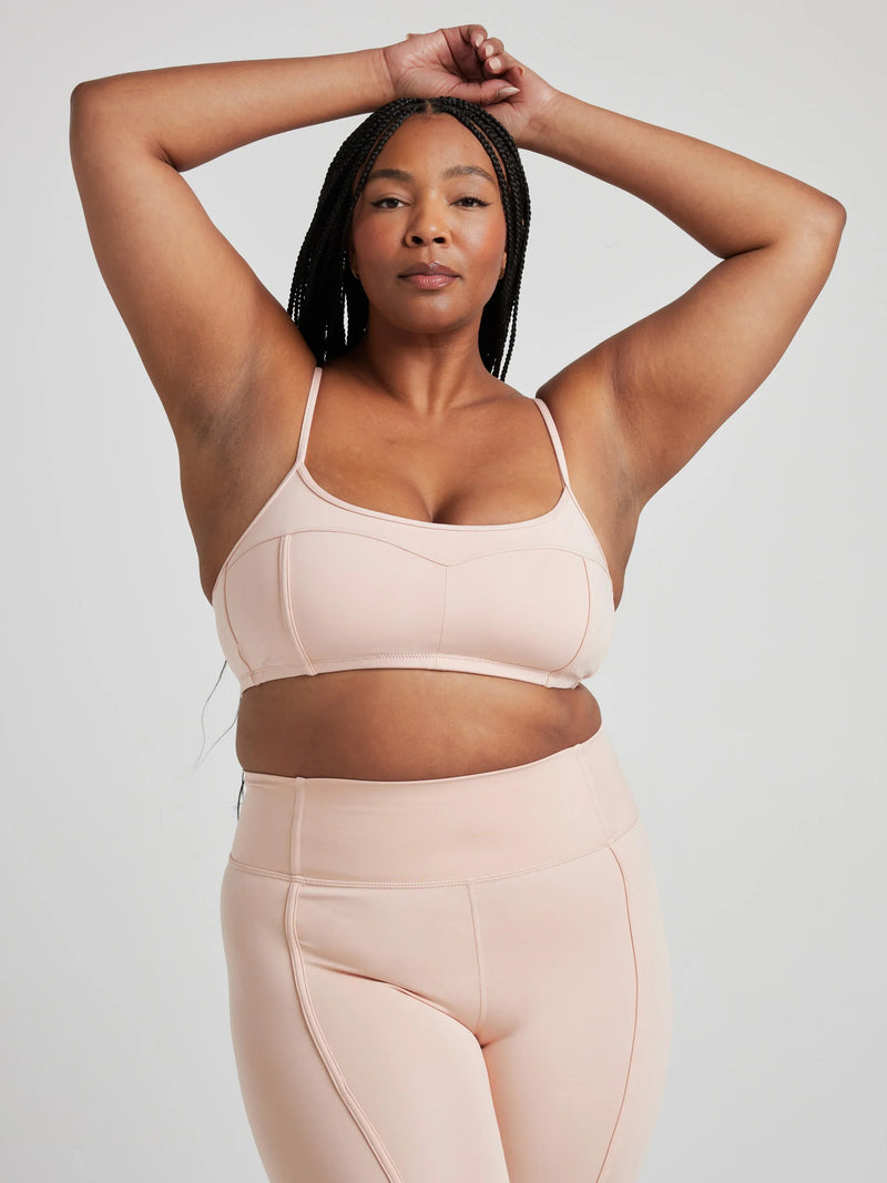 Model poses in ballet-pink bralette with corset boning