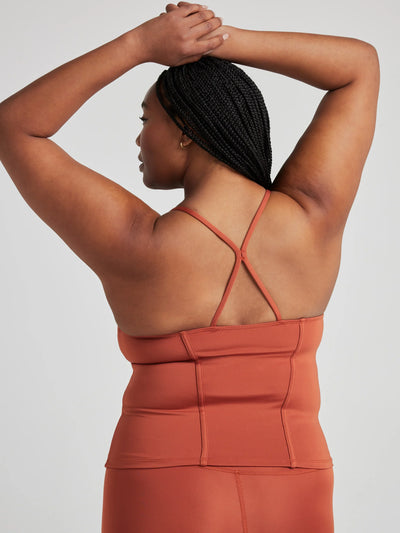 model poses in burnt orange corset tank