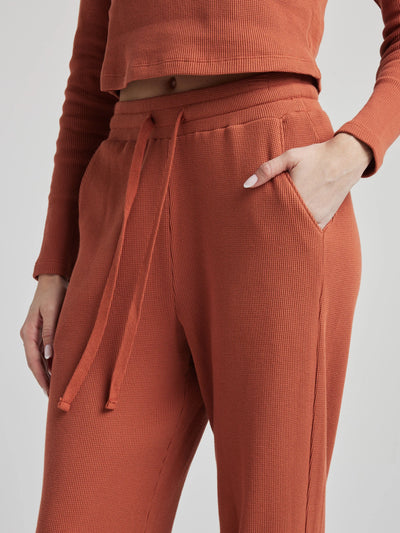 model wears relaxed waffle knit pants in baked clay