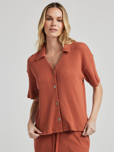 model poses in orange thermal button down with seashell buttons