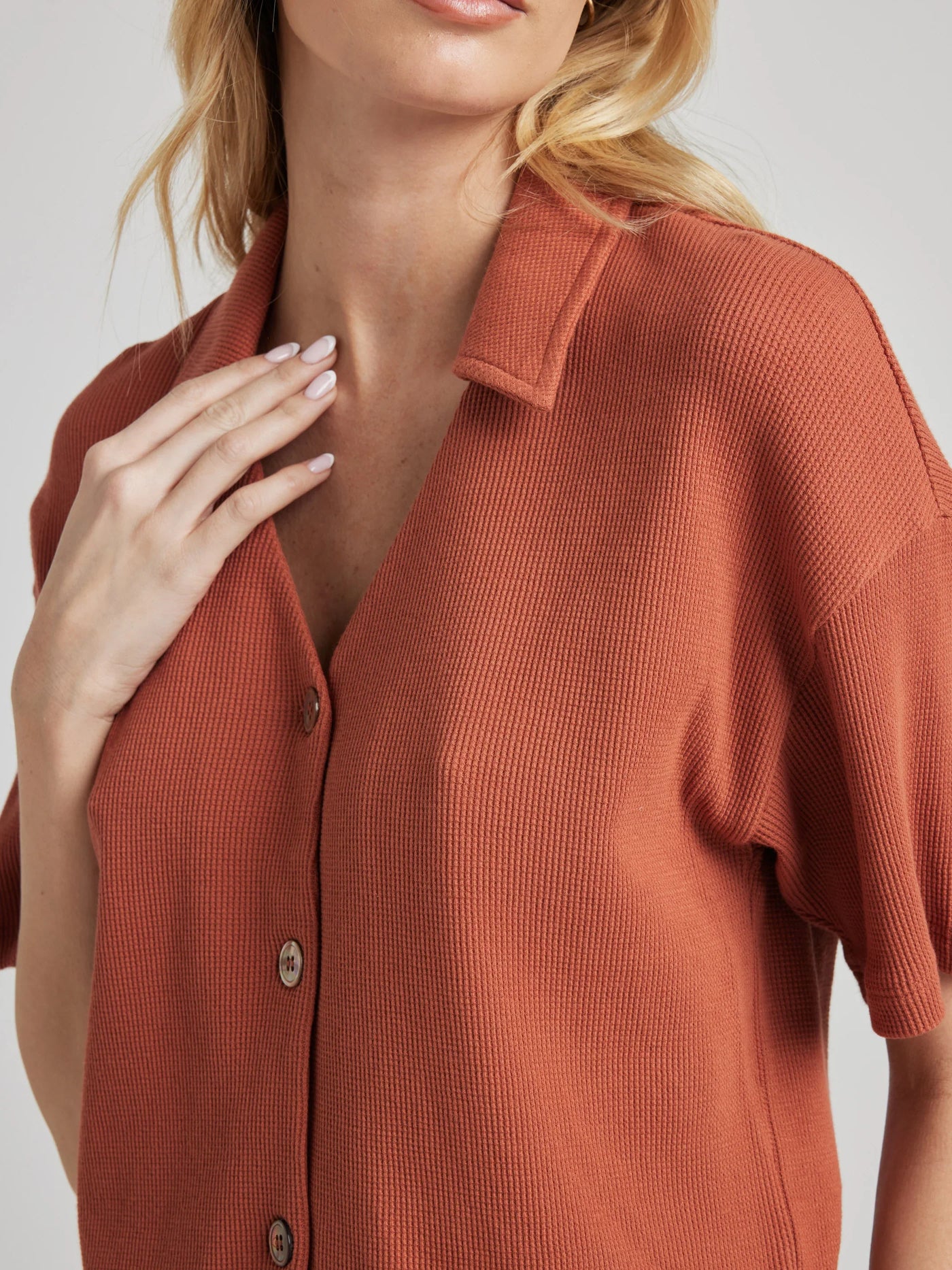 model poses in orange thermal button down with seashell buttons