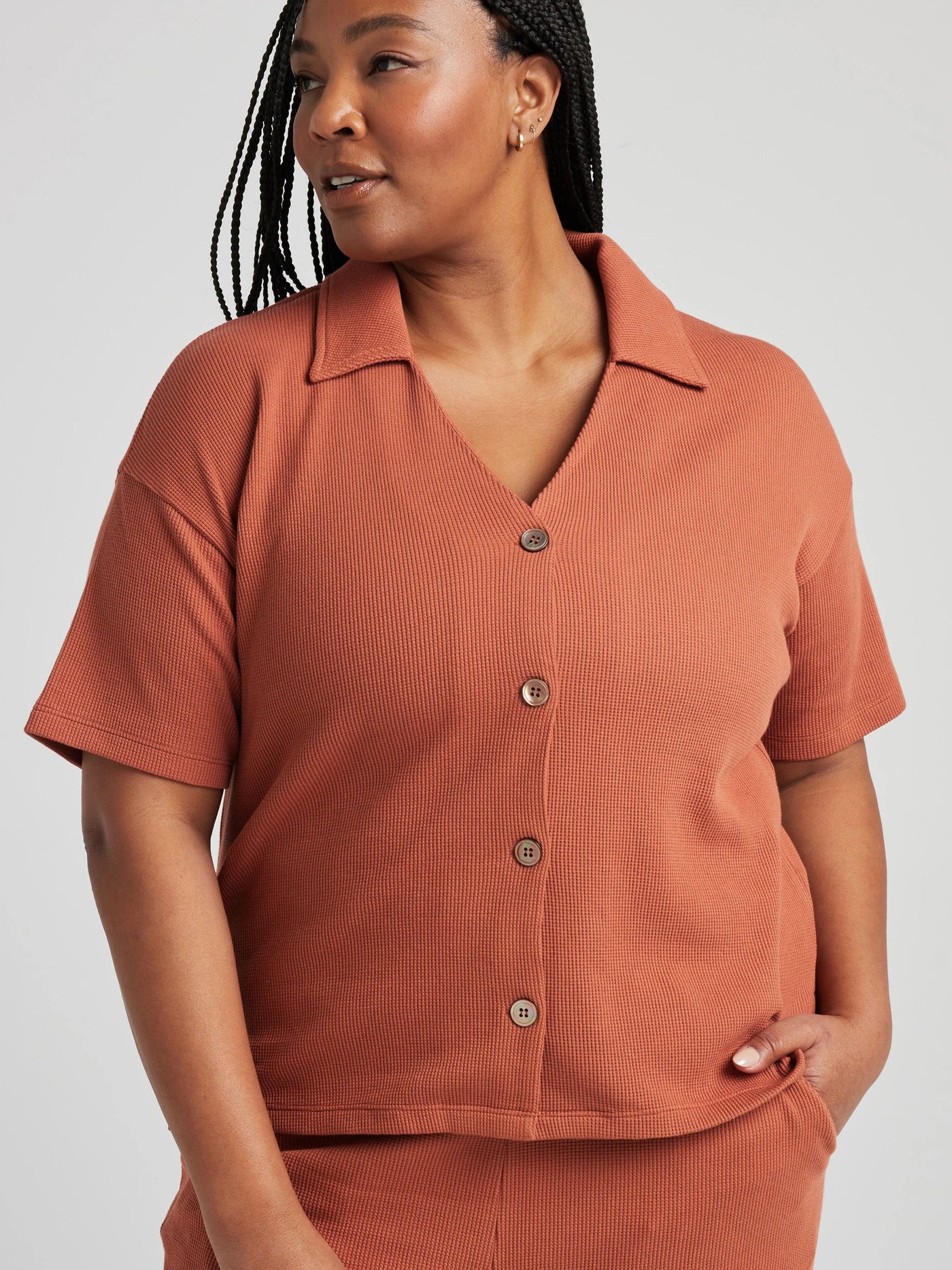 model poses in orange thermal button down with seashell buttons