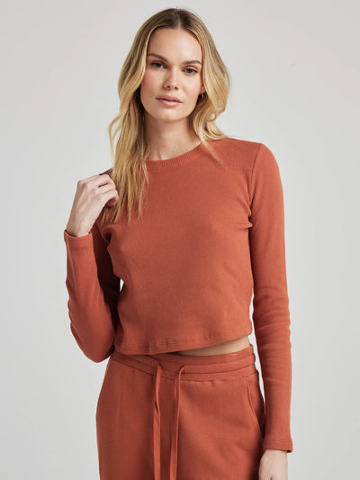 model wears organic thermal long sleeve in orange