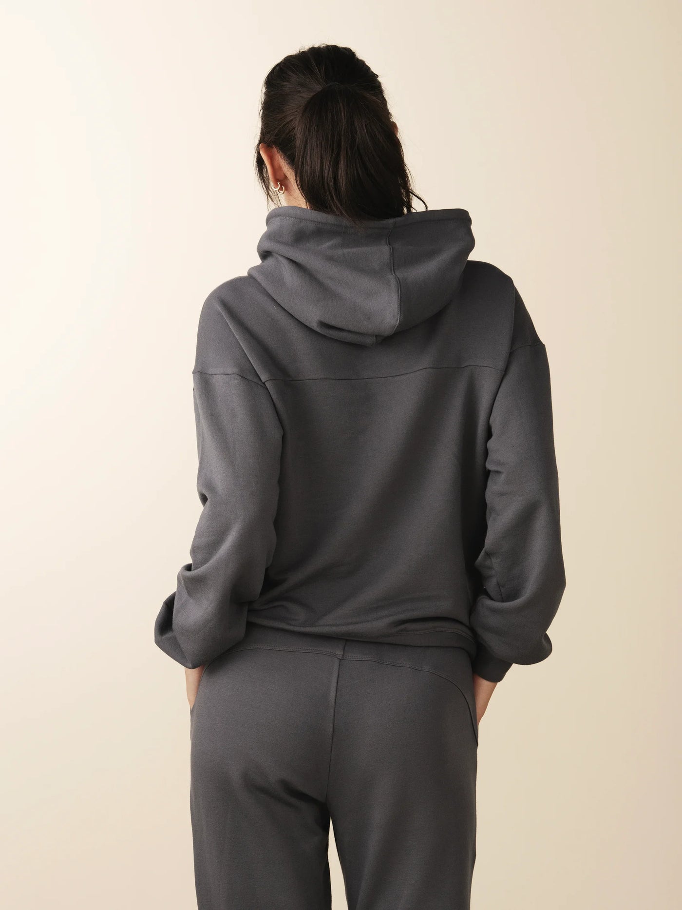 model wears cozy sustainable hoodie with pocket in grey