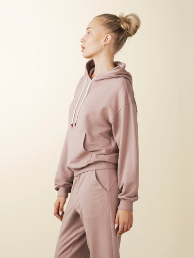 model wears cozy sustainable hoodie with pocket in blush