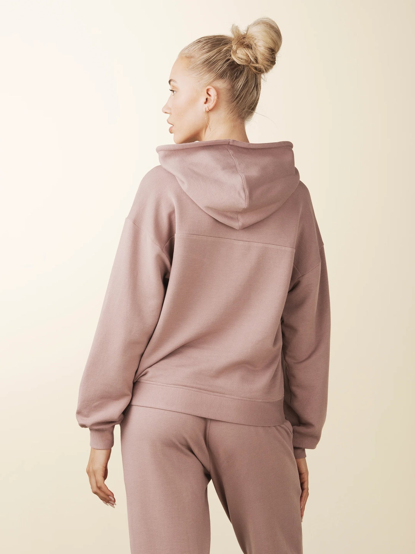 model wears cozy sustainable hoodie with pocket in blush