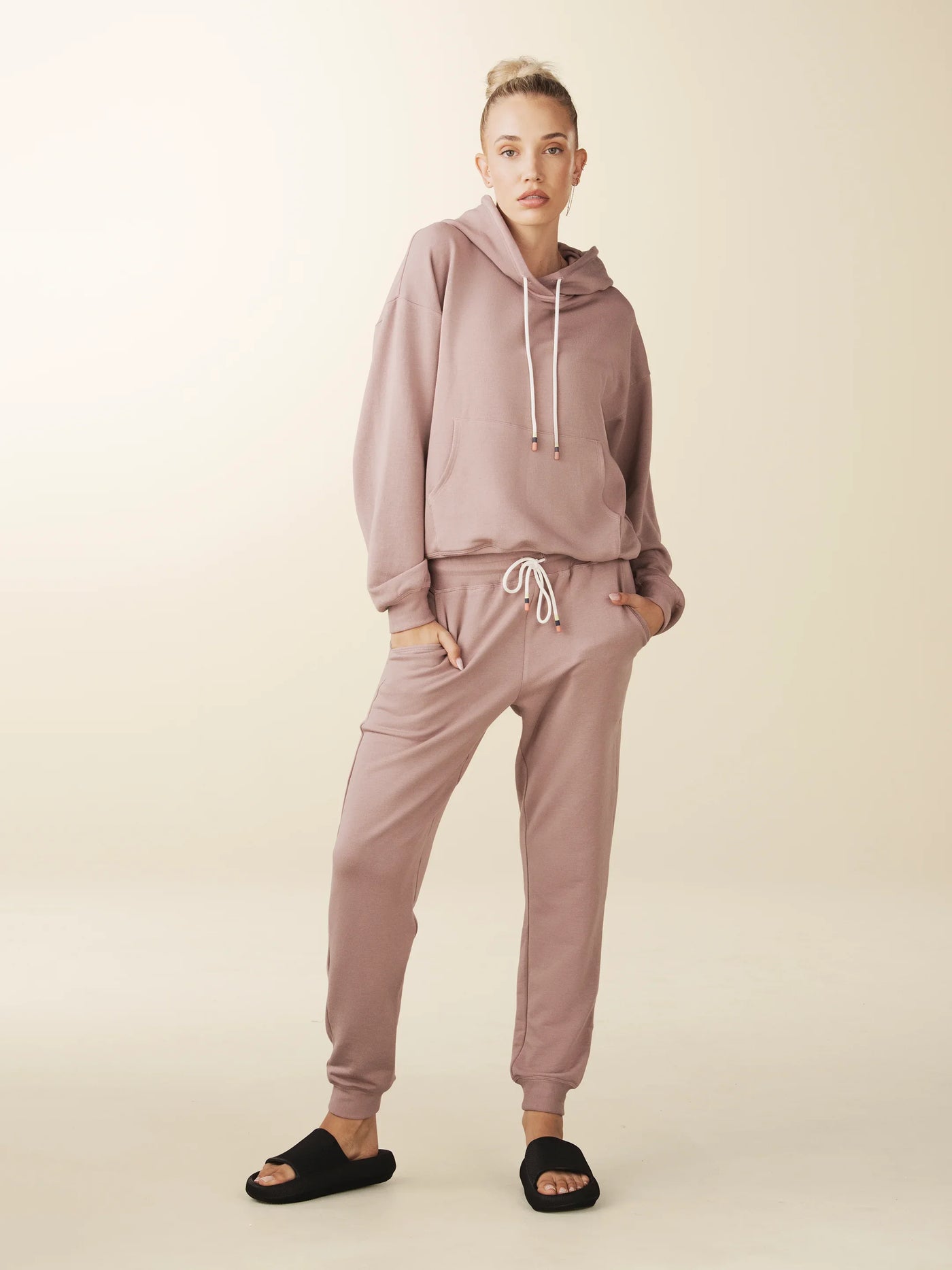 model wears cozy sustainable hoodie with pocket in blush