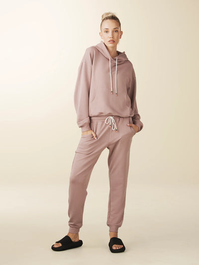 model wears cozy sustainable hoodie with pocket in blush