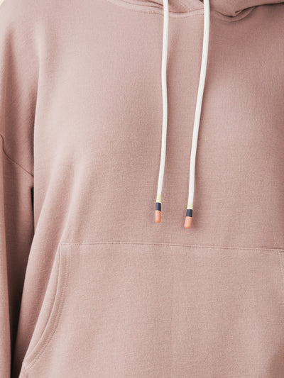 model wears cozy sustainable hoodie with pocket in blush