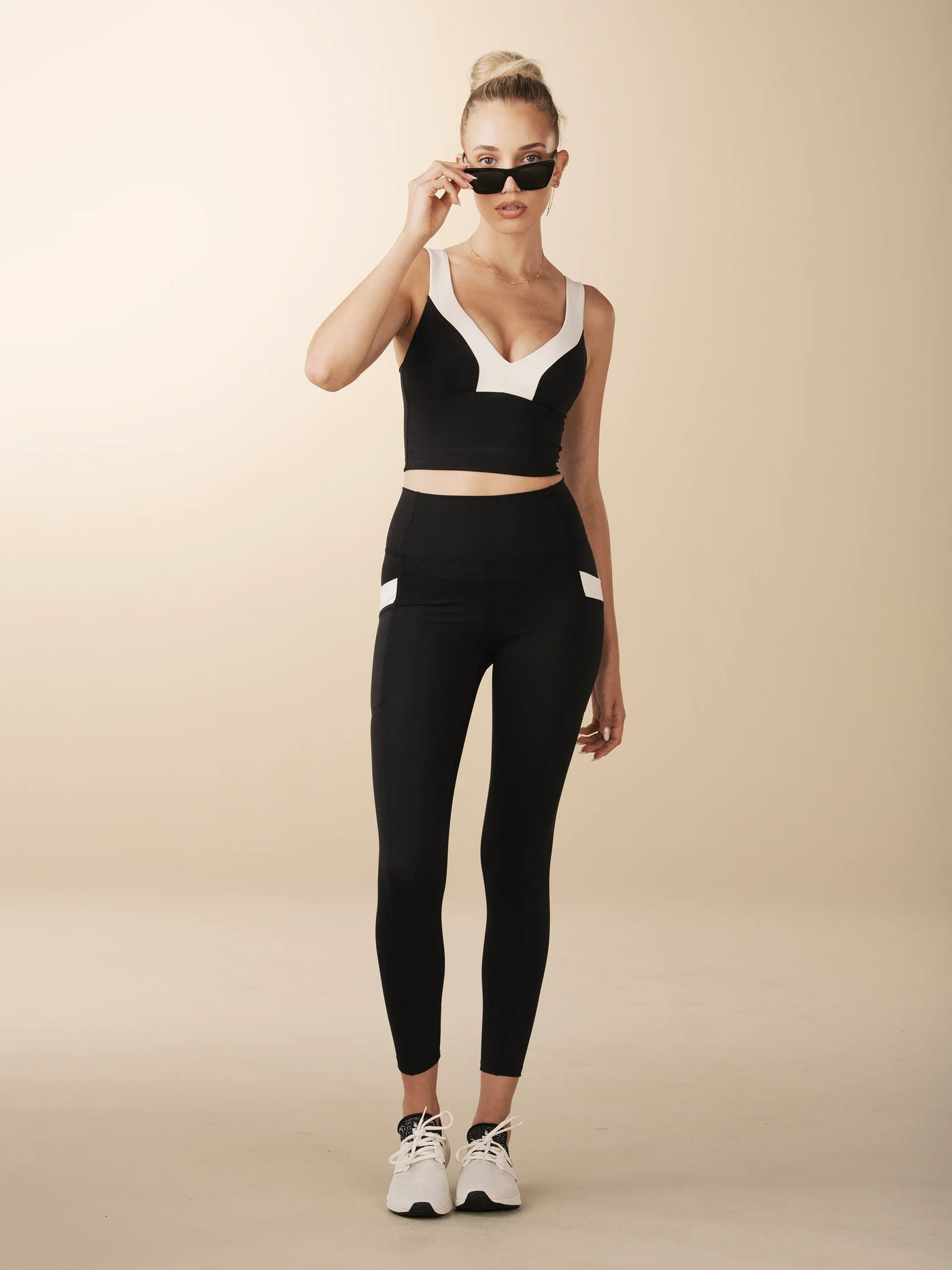 model wears cutest black and cream colorblock sports bra with adjustable straps