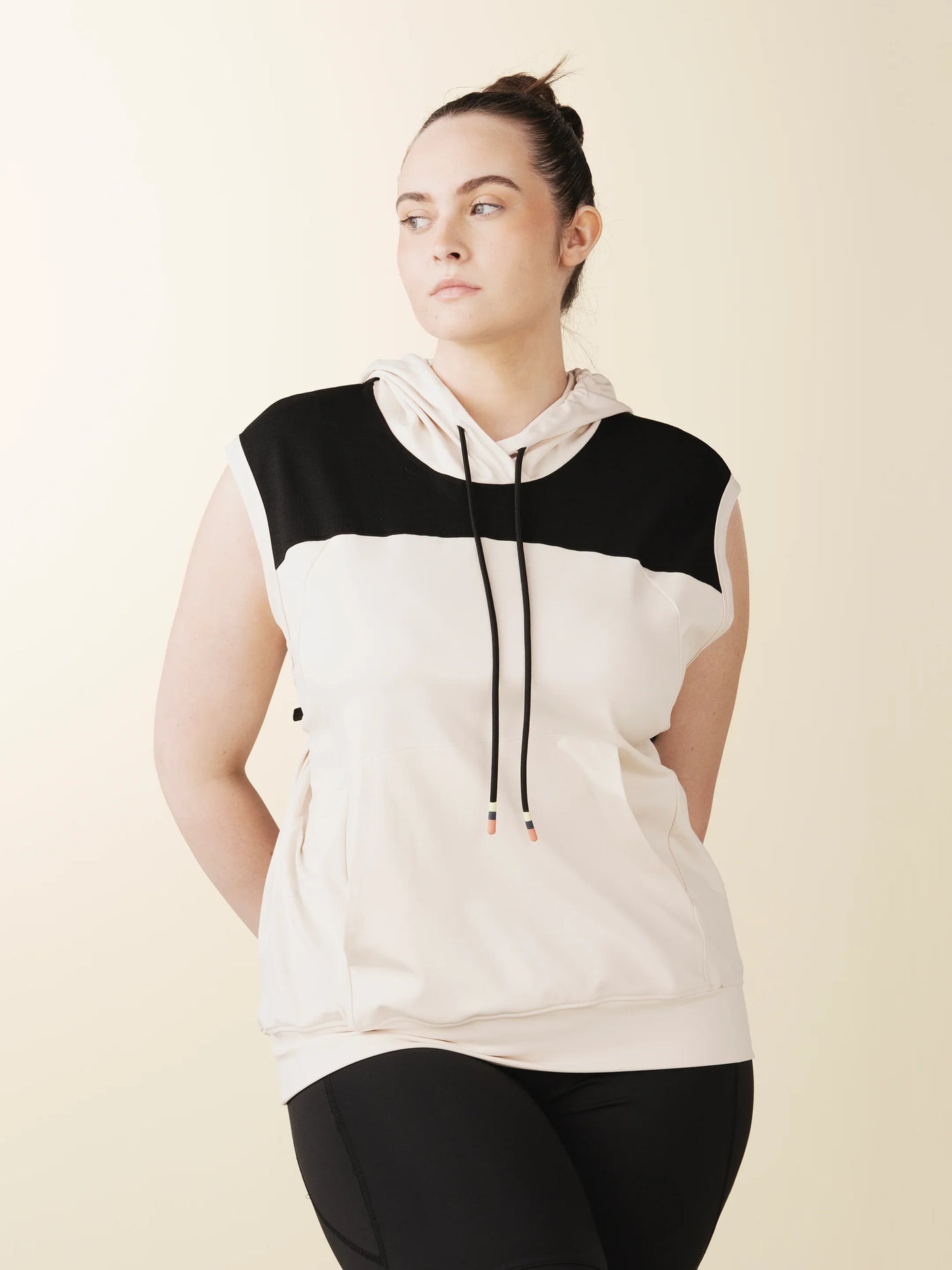 model wears cream colorblock sleeveless hoodie